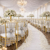 Elegant wedding reception setup with floral centerpieces and gold chairs.