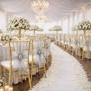 Elegant wedding reception setup with floral centerpieces and gold chairs.