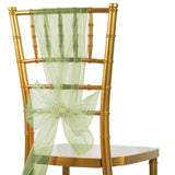 Gold chiavari chair with light green organza sash and decorative bow.