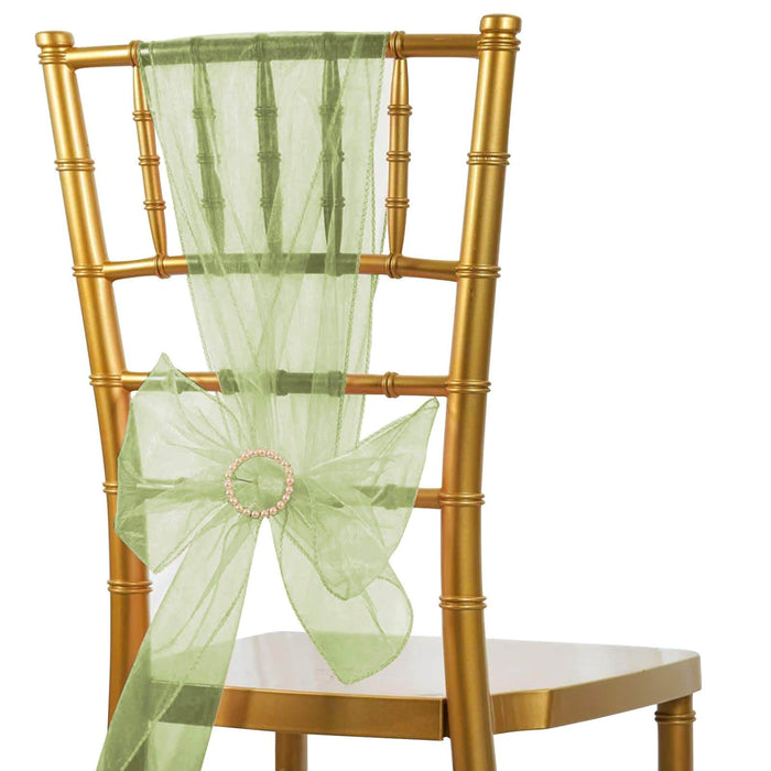 Gold chiavari chair with light green organza sash and decorative bow.