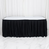 Black table skirt with white tabletop against white studio backdrop