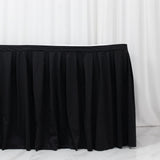 Black pleated table skirt on white backdrop, event table cover
