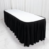 Black rectangular table skirt with white tabletop in a studio setting
