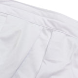 White pleated skirt fabric close-up with waistband stitching