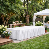 Elegant outdoor wedding reception setup with white tent, flowers, and string lights