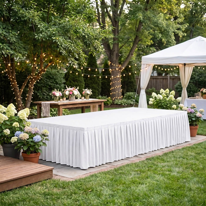 Elegant outdoor wedding reception setup with white tent, flowers, and string lights
