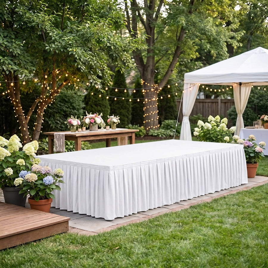 Elegant outdoor wedding reception setup with white tent, flowers, and string lights