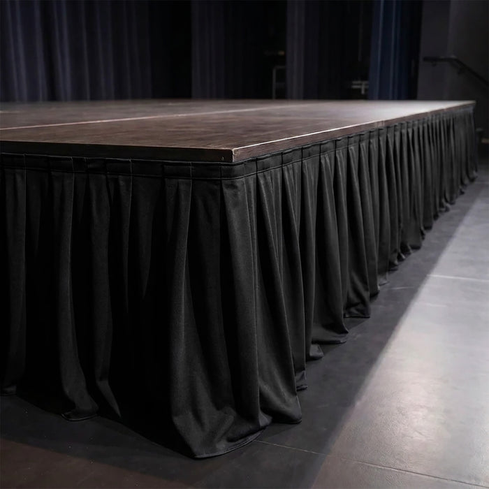 Empty stage with black skirt and wooden platform at an event venue