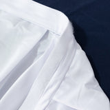 Close-up of white shirt sleeve cuff on dark fabric background