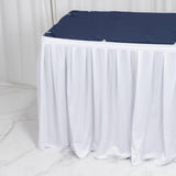 White round table with navy cover and white floor-length table skirt