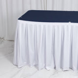White pleated table skirt with navy tabletop cover for events