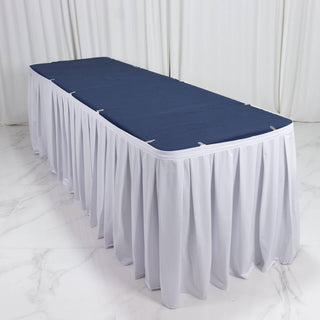 White banquet table with navy tablecloth and draped skirt, event table setup