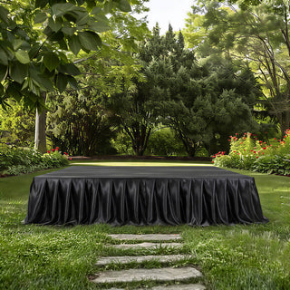 Elegant black-draped outdoor stage in lush garden setting
