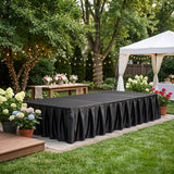 Elegant backyard event setup with black stage, white tent, and floral decor