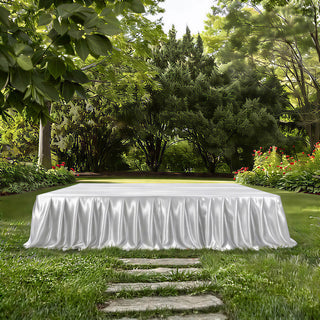 White draped table in lush garden with stone path and tropical greenery