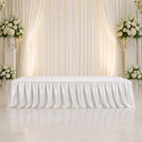 Elegant white wedding stage with floral arrangements and draped backdrop