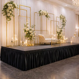 Elegant wedding stage decor with white flowers, gold frames, candles, and sofa