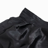 Close-up of black satin fabric with stitched seam and soft folds