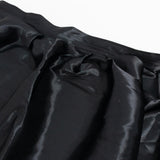 Black satin fabric texture with soft folds and sheen