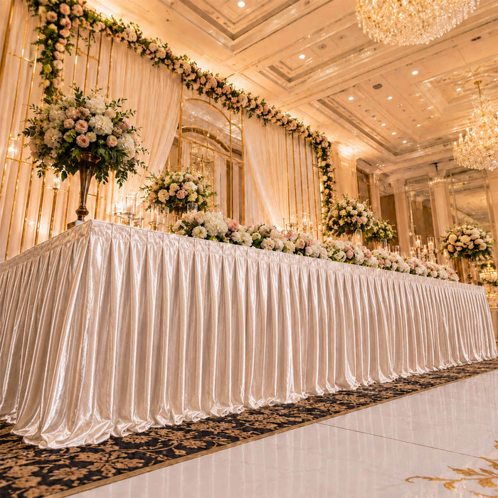 Elegant wedding stage with floral backdrop and champagne draped table setup