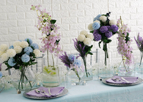 White and blue flower arrangements in glass vases