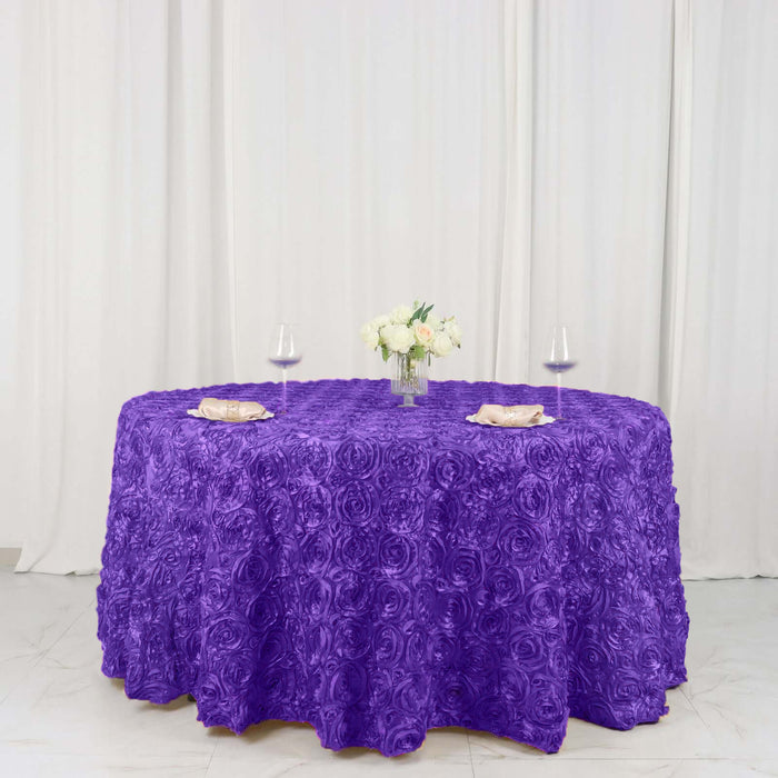 Purple rose-patterned tablecloth with floral centerpiece and glasses.