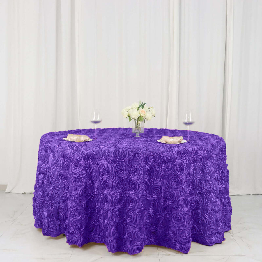Purple rose-patterned tablecloth with floral centerpiece and glasses.