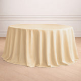 Round ivory tablecloth draping over a circular table in a staged setting.