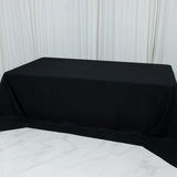 Black tablecloth draped over a table in a studio setting.