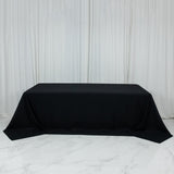 Black tablecloth draped over a rectangular table in a studio setting.