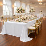 Elegant wedding reception table with floral centerpieces and gold chairs.