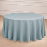 Round light blue tablecloth draped over a round table in a staged setting.