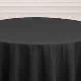 Round black tablecloth on a plain surface.