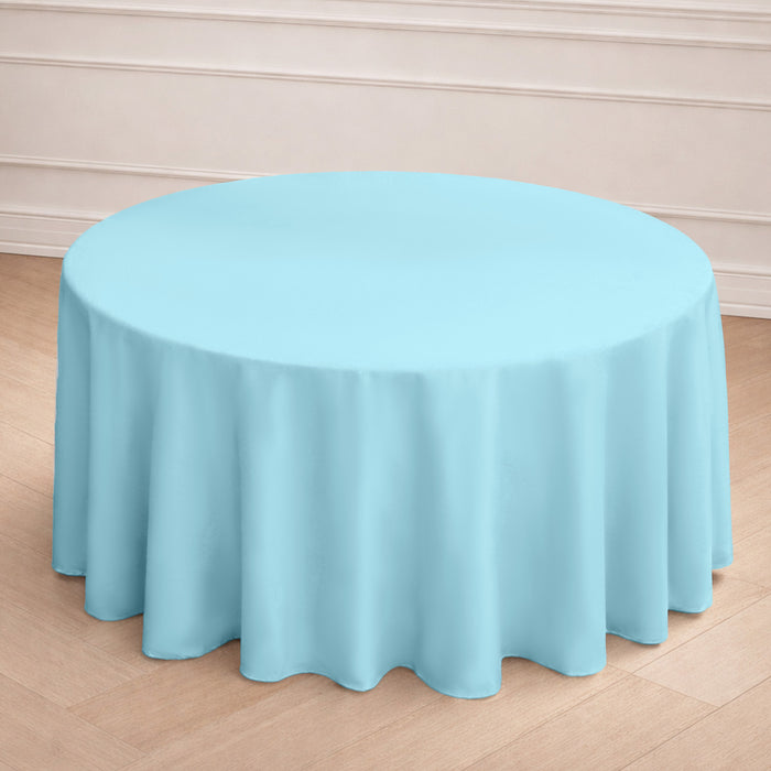 Round light blue tablecloth on a wooden floor.