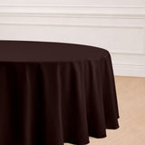 Brown round tablecloth on a wooden floor with elegant draping.