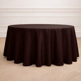 Round brown tablecloth on a wooden floor in a bright, elegant setting.