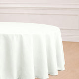 Round white tablecloth on a wooden floor in a stylish setting.