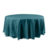 Round teal tablecloth on a plain white backdrop