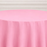 Pink round tablecloth on a white table in a studio setting.