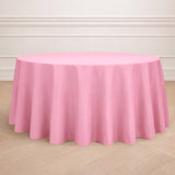 Round pink tablecloth on a wooden floor.