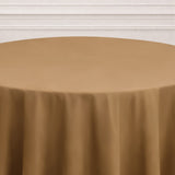 Brown tablecloth on a round table with a neutral backdrop.