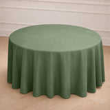Round green tablecloth draped over a circular table in a simple setting.