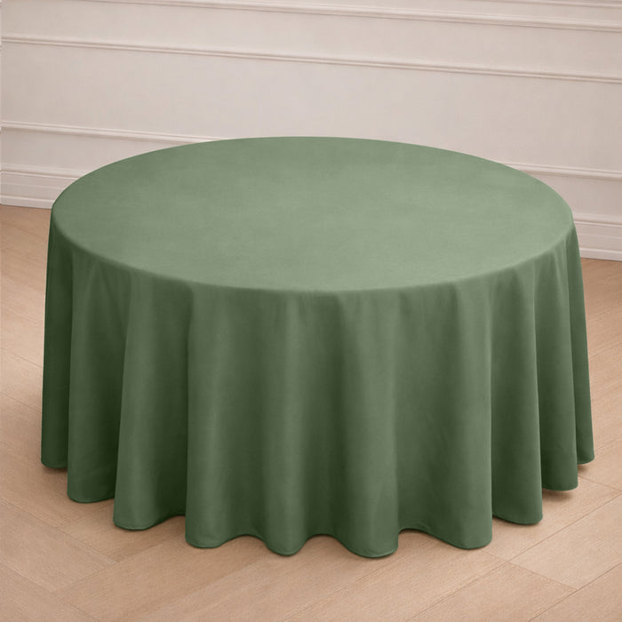 Round green tablecloth draped over a circular table in a simple setting.