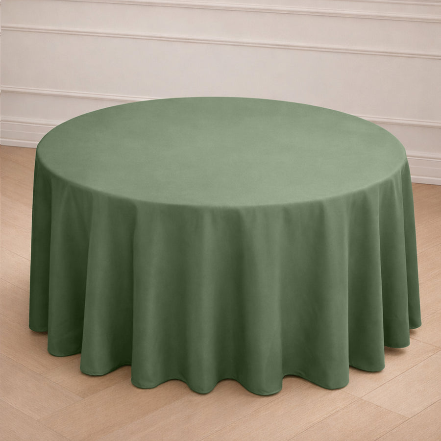 Round green tablecloth draped over a circular table in a simple setting.