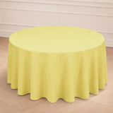Yellow round tablecloth on a wooden floor in a bright setting.