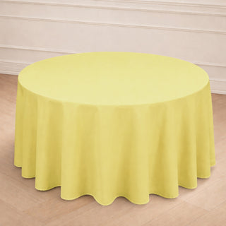 Yellow round tablecloth on a wooden floor in a bright setting.