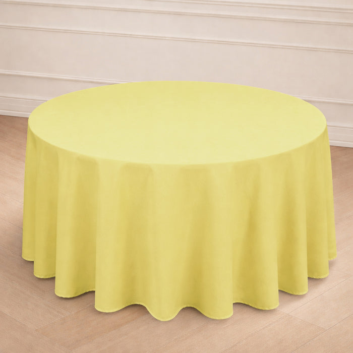 Yellow round tablecloth on a wooden floor in a bright setting.
