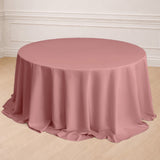 Round pink tablecloth draping over a round table in a styled setting.