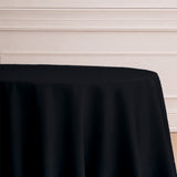 Black tablecloth draping over a round table.