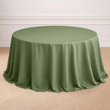 Round olive green tablecloth draped elegantly on a wooden table.